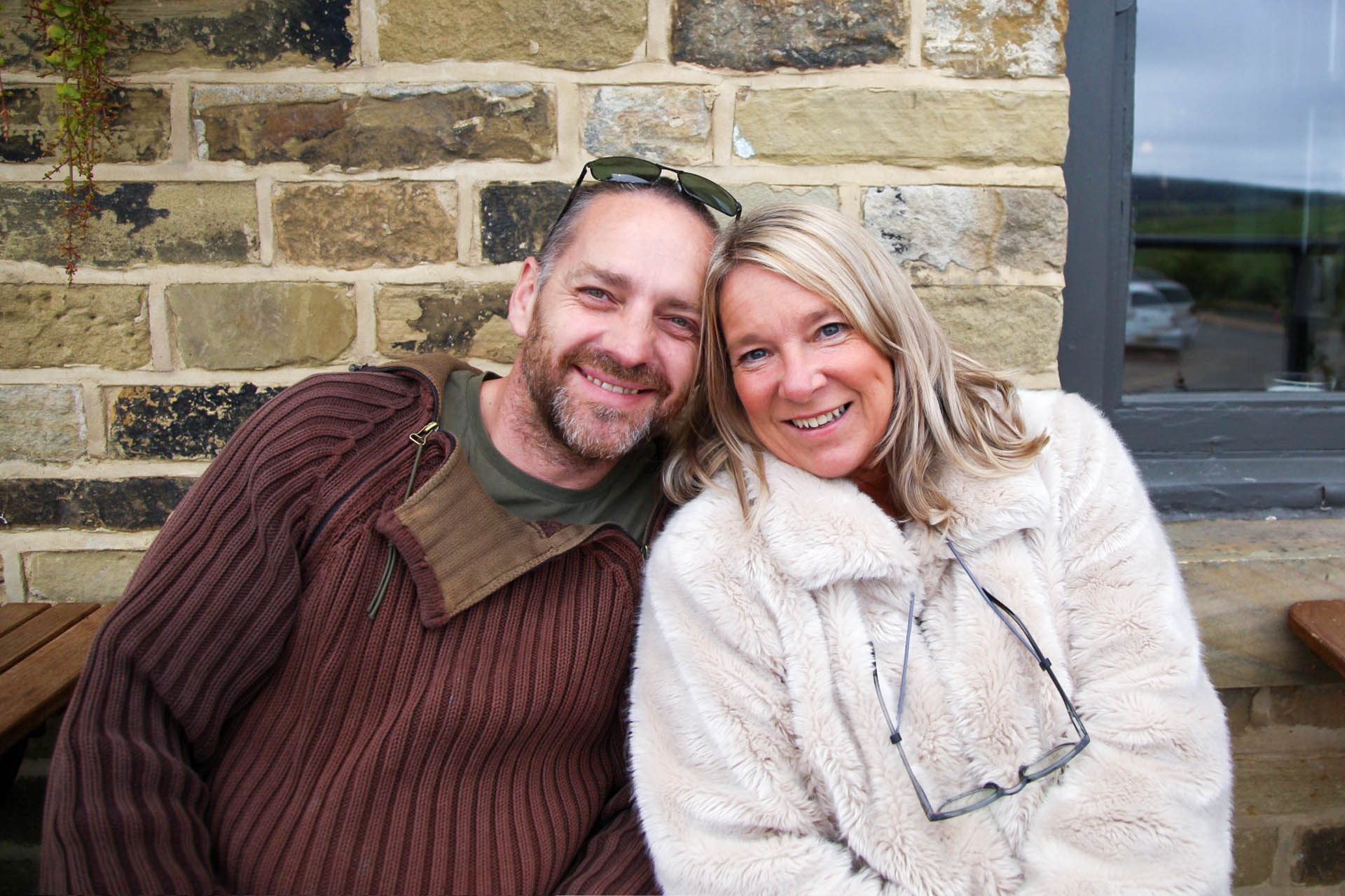 woman in leopard print coat holding black cat