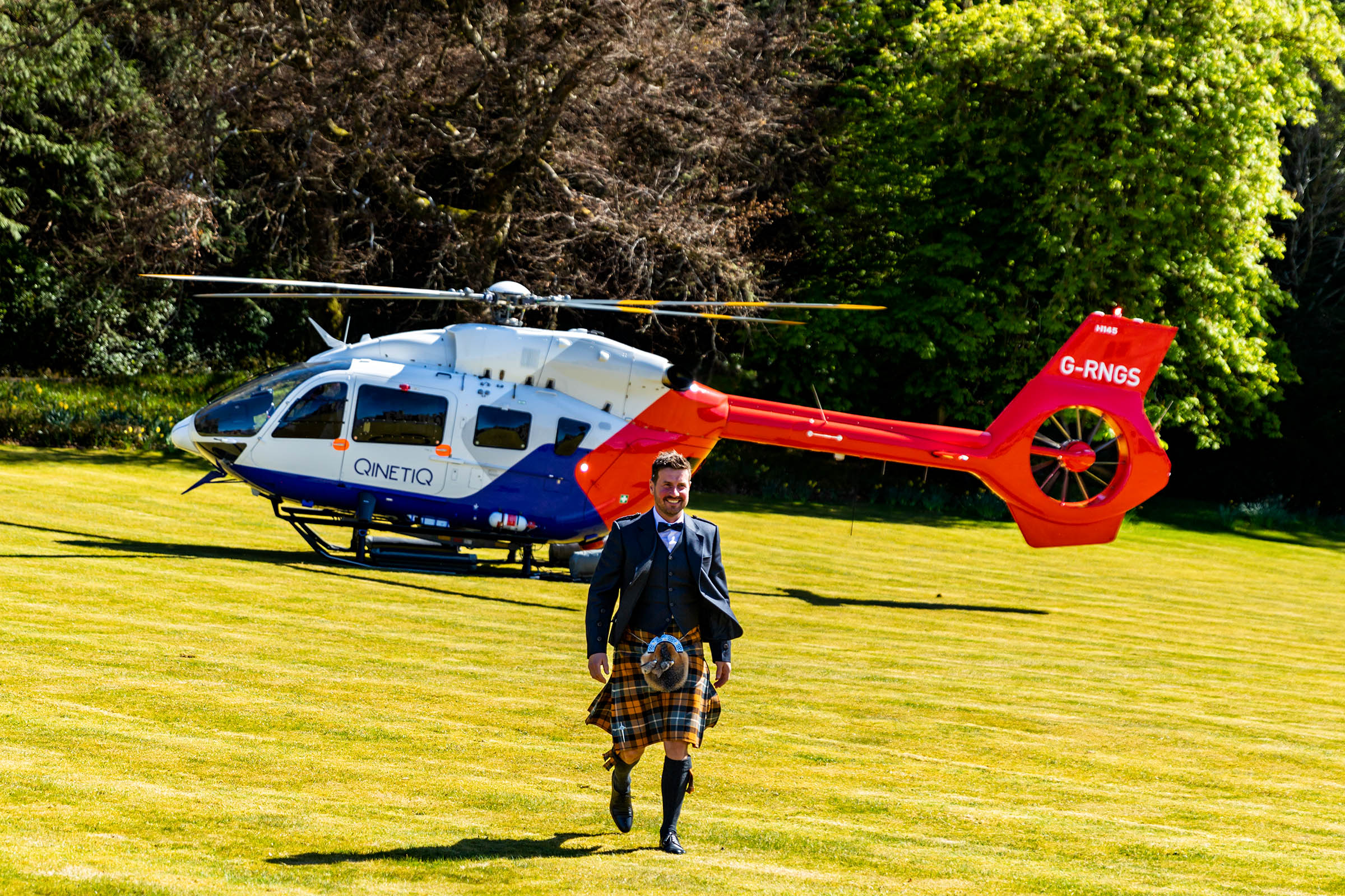 Man walking away from red helicopter