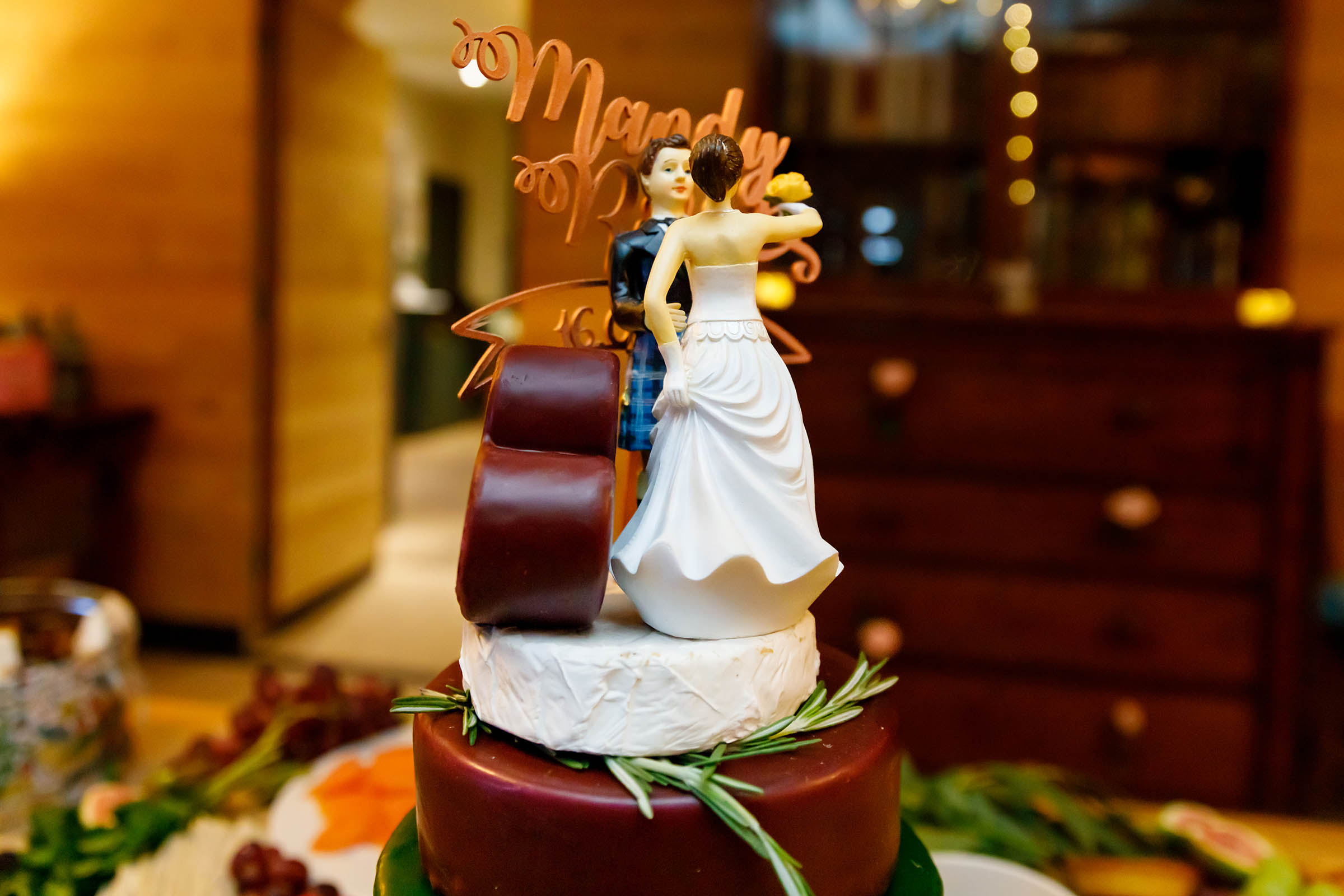 grazing table full of cheese , salami grapes and a cheese wedding cake