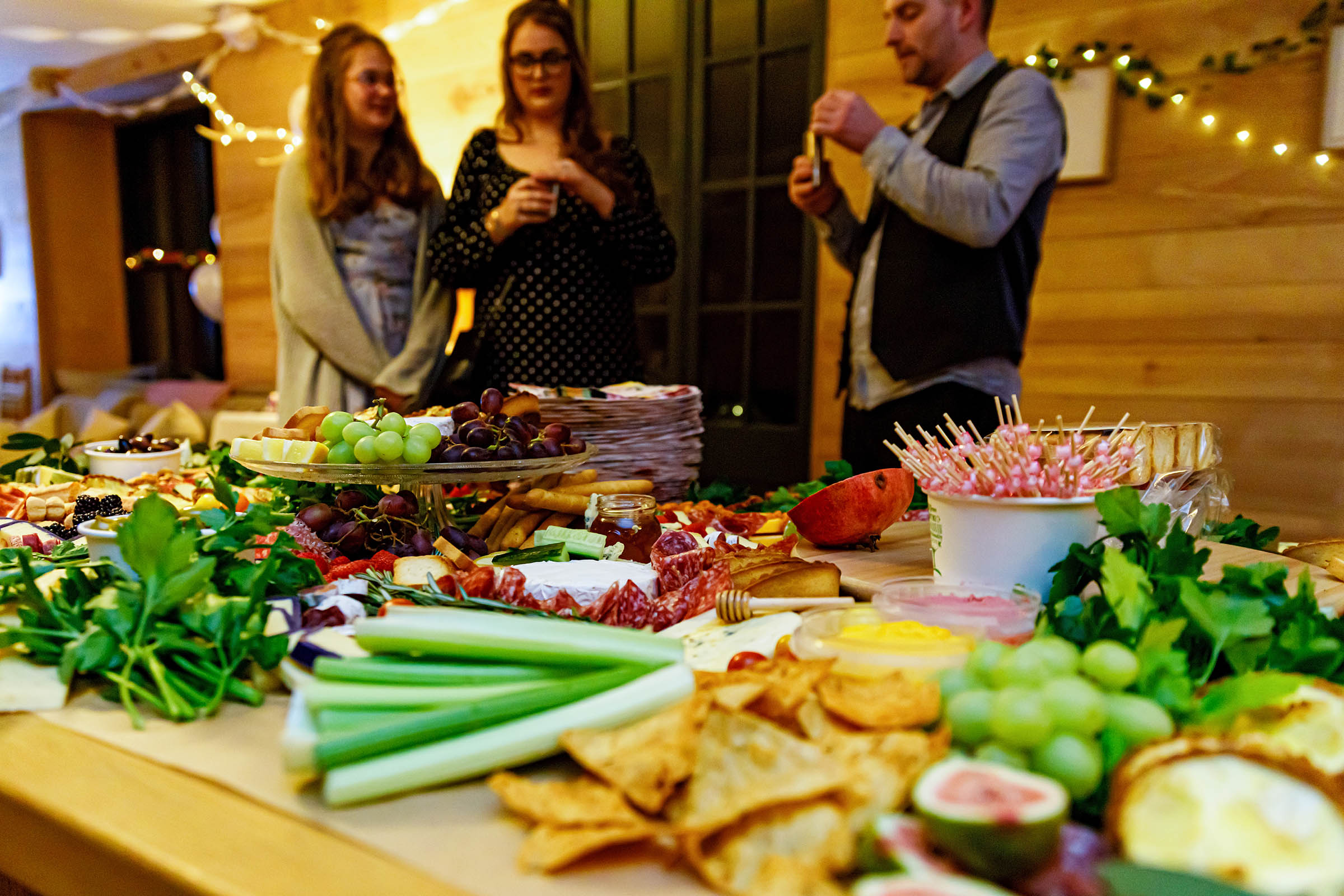 grazing table full of cheese , salami grapes and a cheese wedding cake